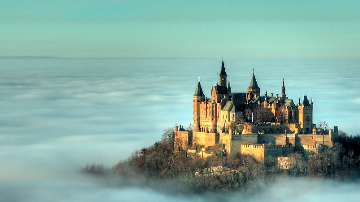 Die Burg Hohenzollern (bei Hechingen im Zollernalbkreis) inmitten einer Inversionswetterlage im dichten Wolkenmeer, Foto vom Donnerstag (10.11.2011). Bei einer Inversion sind die unteren Luftschichten kühler und somit höher verdichtet und werden von den darüber liegenden wärmeren Schichten abgeschirmt, beziehungsweise unterdrückt. Da sich der Novembernebel daher nicht nach oben hin ausbreiten kann, bedeckt er das Tal und umschließt die Burg bis auf Höhe deren Grundmauern. Die um 1850 erbaute Burg ist der Stammsitz der preußisch-brandenburgischen wie der fürstlich-katholischen Linie des Hauses Hohenzollern und ein beliebtes Ausflugsziel. Foto: Roland Beck dpa/lsw  +++(c) dpa - Bildfunk+++