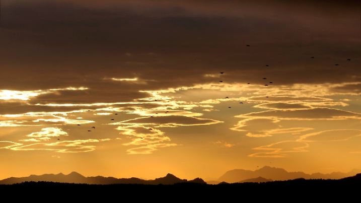 Föhnwolken stehen am 23.10.2013 bei Sonnenaufgang über den Bergen, aufgenommen in Icking (Bayern). Der warme Fallwind aus den Alpen sorgte in der Nacht stellenweise für ungewöhnliche Tiefsttemperaturen von über 20 Grad Celsius. Foto: Stephan Jansen/dpa +++(c) dpa - Bildfunk+++