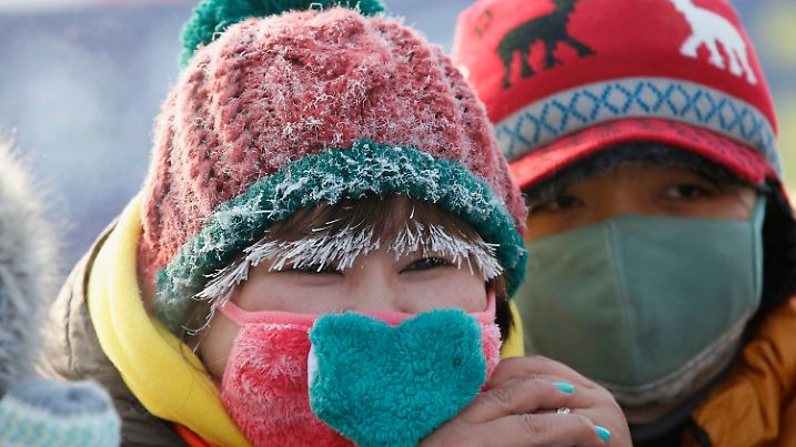 Frost lines the hair of a spectator as she watches swimmers competing in a pool carved into the thick ice covering the Songhua River during the Harbin Ice Swimming Competition in the northern city of Harbin, Heilongjiang province January 5, 2014. According to organisers, about 700 swimmers across China took part in the event on the official launch day of the Harbin Ice and Snow Sculpture Festival. REUTERS/Kim Kyung-Hoon (CHINA - Tags: SOCIETY SPORT SWIMMING ENVIRONMENT)