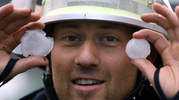 Ein Feuerwehrmann hält am Mittwoch (28.06.2006) in Villingen-Schwenningen (Schwarzwald-Baar-Kreis) Hagelkörner in Tischballgröße in den Händen. Ein Hagelunwetter hat in der Doppelstadt massive Schäden angerichtet. Foto: Patrick Seeger dpa/lsw +++(c) dpa - Bildfunk+++