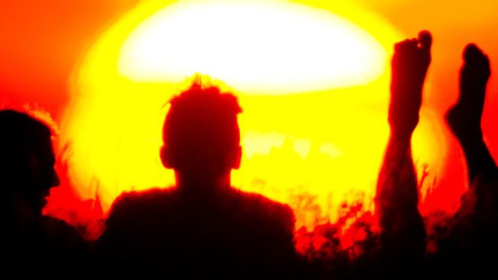 Drei Männer sitzen am 17.07.2014 in Berlin bei Sonnenuntergang auf dem Teufelsberg. Foto: Daniel Bockwoldt/dpa