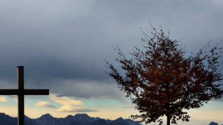 Ein herbstlicher Baum und ein Gipfelkreuz stehen am Samstag (05.11.2011) auf dem Auerberg bei Stötten (Schwaben) vor dem Panorama der Allgäuer Alpen. Ein Wechsel aus Sonne, Wolken und Nebel bestimmt das Wetter im Süden Bayerns. Eine Föhnwetterlage sorgt am Alpenrand für Temperaturen bis zu 20 Grad. Foto: Karl-Josef Hildenbrand dpa/lby +++(c) dpa - Bildfunk+++