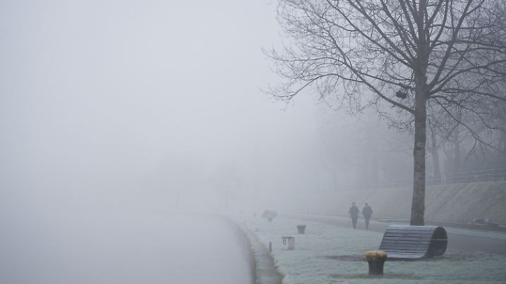 Zwei Spaziergängerinnen laufen am 21.01.2015 bei dichtem Nebel am Mainufer in Offenbach am Main (Hessen) entlang. Foto: Christoph Schmidt/dpa +++(c) dpa - Bildfunk+++