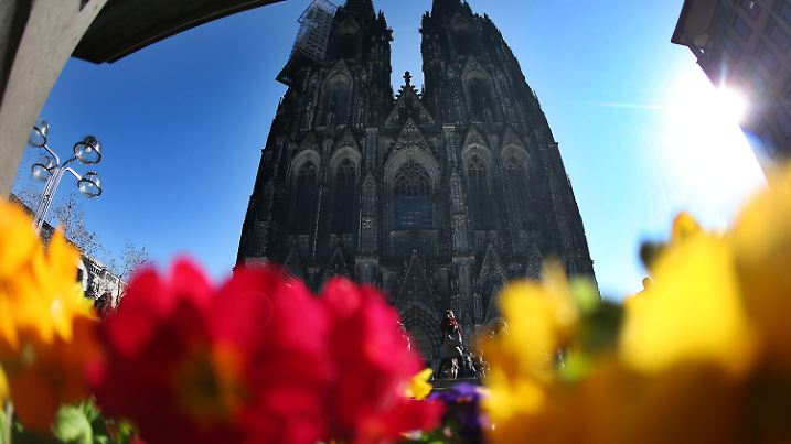 Die Sonne scheint am 12.03.2015 in Köln (Nordrhein-Westfalen) am Dom in ein Beet mit Frühlingsblumen. Foto: Oliver Berg/dpa +++(c) dpa - Bildfunk+++