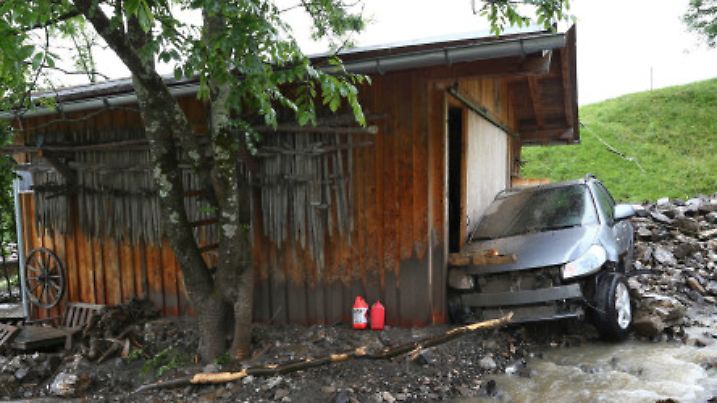 Ein von einer Schlammlawine beschädigtes Auto steht am 15.06.2015 an einer Hütte in Oberstdorf (Bayern). Einen Tag nach dem Abgang der Schlammlawine sind die Aufräumarbeiten in dem betroffenen Gebiet in vollem Gange. Foto: Karl-Josef Hildenbrand /dpa +++(c) dpa - Bildfunk+++