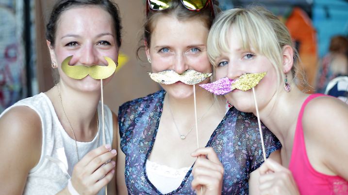 Mit einem Hipster-Bart posieren Besucherinnen des Hipster Cups am 04.07.2015 in Berlin. Foto: Jörg Carstensen/dpa (zu dpa "Coolness statt Hitze beim fünften Hipster Cup in Berlin" am 04.07.2015) +++(c) dpa - Bildfunk+++