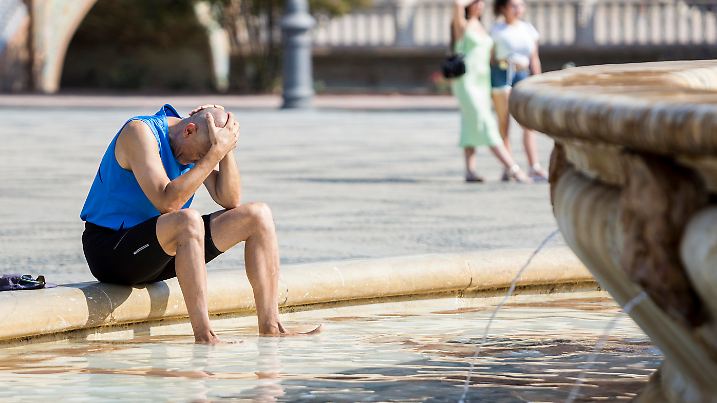 Ein Mann kühlt sich im zentralen Brunnen auf der Plaza de España in Sevilla ab. In 16 der insgesamt 17 Autonomen Gemeinschaften Spaniens sollte am Donnerstag weiterhin Hitzealarm gelten, in fünf dieser Regionen teilweise sogar Alarmstufe Rot, darunter auch in Sevilla.