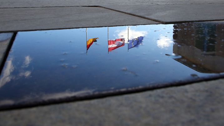 22.02.2019, Berlin: In einer Regenpfütze im Ehrenhof des Bundeskanzleramtes spiegeln sich die Flaggen Deutschlands, Lettlands und Europas wieder, bevor der lettische Staatspräsident von der Bundeskanzlerin empfangen wird. Foto: Wolfgang Kumm/dpa +++ dpa-Bildfunk +++