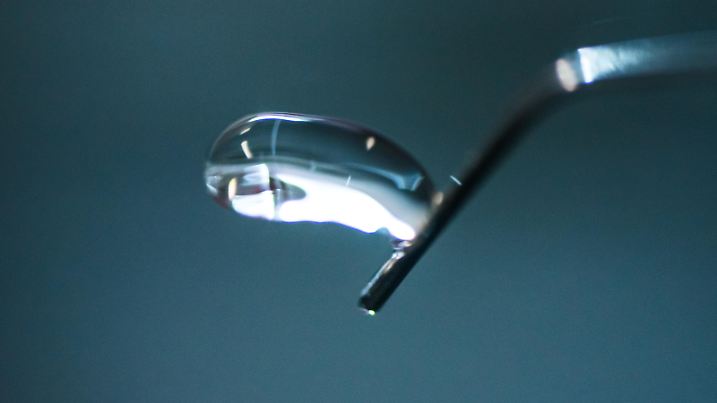 18.12.2018, Rheinland-Pfalz, Mainz: Ein Wassertropfen löst sich im Windkanal von der Kanüle. In einem windkanalähnlichen Versuchsaufbau wird an der Uni Mainz das Verhalten von Wolkenteilchen wie Wassertropfen, Graupel- oder Hagelkörnern unter dem Einfluss von unterschiedlicher Temperatur und Windgeschwindigkeit erforscht. (zu dpa vom 15.01.2019: «Mikroskop in die Wolken» - einzigartiger Windkanal in Mainz) Foto: Andreas Arnold/dpa | Verwendung weltweit