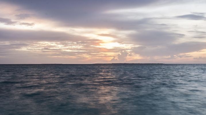 21.09.2018, Malediven, Hanimaadhoo: Die Sonne geht hinter dem Horizont unter. (Aufnahme mit Langer Belichtungszeit) | Verwendung weltweit