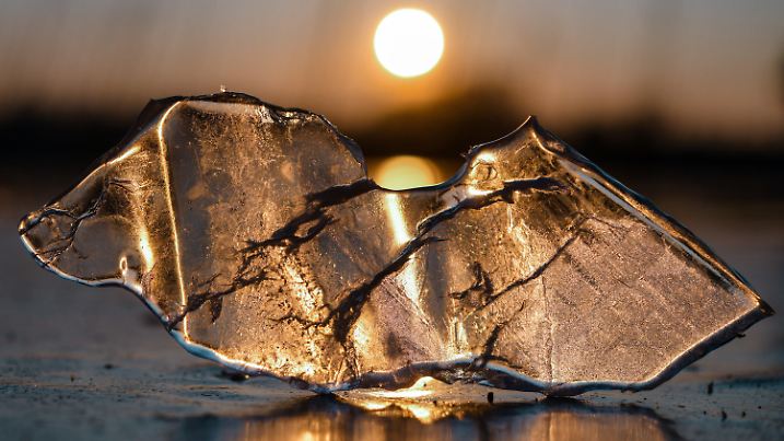 dpatopbilder - 03.03.2018, Brandenburg, Falkenhagen: Ein Stück Eis liegt im Gegenlicht des Sonnenuntergangs auf dem zugefrorenen Schwarzen See im Landkreis Märkisch-Oderland. Der See ist mit einer etwa zehn Zentimeter starken Eisdecke komplett zugefroren. Foto: Patrick Pleul/dpa-Zentralbild/dpa +++ dpa-Bildfunk +++