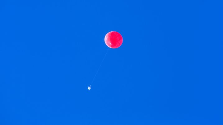 Ein Ballon mit einer Ozon- und Radiosonde steigt am 09.04.2015 in Ny-Ålesund auf Spitzbergen (Norwegen) in der Forschungsbasis AWIPEV auf. Die Messwerte der Ozon- und Radiosonde werden während des Flugs bis in Höhen von über 30 Kilometern erfasst und zur Station gefunkt. Foto: Jens Büttner /dpa | Verwendung weltweit
