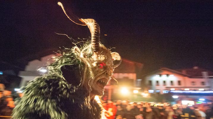 28.12.2018, Bayern, Sankt Englmar: Furchterregende Gesellen treiben ihr Unwesen während der «Rauhnächte». Mit kunstvoll handgeschnitzten Masken und wilden Pelzgewändern ziehen in den «Rauhnächten» in der Zeit zwischen Weihnachten und Dreikönig in vielen Gemeinden im Bayerischen Wald Hexen, Teufel und Dämonen lautstark durch die Straßen, um die bösen Geister zu vertreiben. Foto: Armin Weigel/dpa | Verwendung weltweit