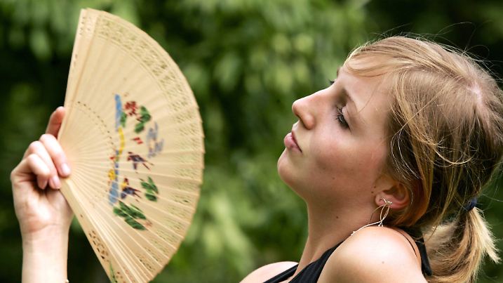 Gegen die schwüle Luft wedelt sich Maike am Dienstag (22.05.2007) im Stadtpark in Moers mit einem Fächer eine frische Brise zu. Bei Temperaturen um 25 Grad und bedecktem Himmel ist es außergewöhnlich schwül, Gewitter sollen am Abend nicht nur in Nordrhein-Westfalen für Abkühlung sorgen. Foto: Roland Weihrauch dpa/lnw +++(c) dpa - Report+++ | Verwendung weltweit