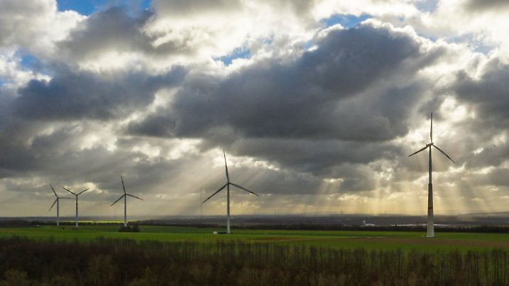 ARCHIV - 14.09.2017, Nordrhein-Westfalen, Grevenbroich: Die Sonne scheint durch eine Wolkendecke auf Windräder. In Nordrhein-Westfalen sind im vergangenen Jahr voraussichtlich deutlich weniger neue Windenergieanlagen in Betrieb genommen worden als 2017. (zu dpa «Deutlich weniger neue Windräder in NRW in Betrieb genommen» vom 17.01.2019) Foto: Christophe Gateau/dpa +++ dpa-Bildfunk +++