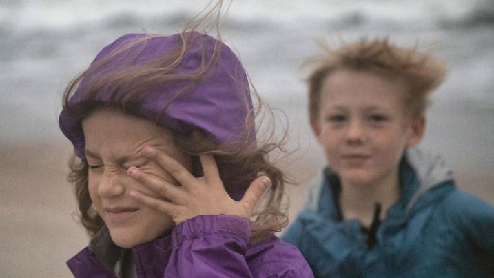 13.09.2018, USA, Atlantic Beach: Cecile Sullivan, 5, wischt sich beim Spaziergang am Strand mit ihrem Bruder Henry Sullivan, 7, in der Nähe des Oceanana Pier & Pier House Restaurants über das Gesicht. Mit peitschendem Regen und Windgeschwindigkeiten von bis zu 150 Kilometern pro Stunde hat Hurrikan «Florence» noch vor seinem eigentlichen Auftreffen die US-Ostküste heimgesucht. Foto: Travis Long/Raleigh News & Observer/Zuma/dpa +++ dpa-Bildfunk +++