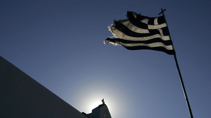 Griechische Flagge weht im Wind an einer Kapelle im Gegenlicht auf der Kykladen-Insel Kalymnos , Griechenland, Europa | Verwendung weltweit, Keine Weitergabe an Wiederverkäufer.