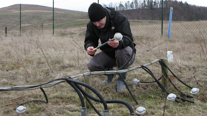 Der Geologe Martin Lonschinski von der Universität Jena, aufgenommen am 21.01.2008 auf der einstigen Wismut-Abraumhalde in der Nähe von Kauern bei Ronneburg (Thüringen) beim Prüfen eines Tensiometers zur Messung der Bodenfeuchte. Obwohl die Halde längst abgetragen ist, hat sich in rund zehn Jahren hier nur eine karge Vegetation entwickelt. Auf dem Gelände der ehemaligen Gessenhalde, die die Wismut zu DDR-Zeiten bei der Urangewinnung angelegt hat, haben die Forscher ein 50 Mal 50 Meter großes Testfeld mit Messgeräten eingerichtet, auf dem sie seit dreieinhalb Jahren verschiedene Pflanzen anbauen. In dem Versuch bauen die Wissenschaftler auch auf die Hilfe spezieller Bodenbakterien und Pilze. Die Bakterien (Streptomyceten) sollen den Schwermetallstress für die Pflanzen verringern, die Mykorrhiza-Pilze die Nährstoffaufnahme steigern. Foto: Andreas Hummel dpa/lth (zu Korr.-Bericht lth vom 10.02.2008) +++(c) dpa - Report+++ | Verwendung weltweit