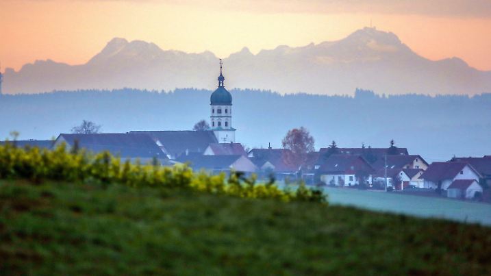 13.11.2018, Baden-Württemberg, Uttenweiler-Ahlen: Blick auf die Kirche von Seekirch am Federsee. Für kurze Zeit ermöglicht die Föhnwetterlage am Morgen einen Blick auf die über hundert Kilometer entfernten Alpen. Foto: Thomas Warnack/dpa +++ dpa-Bildfunk +++