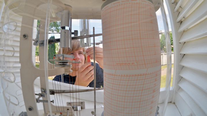 Ein Student der Meteorologie liest am 17.07.2013 vor einer Wetterhütte des Instituts für Meteorologie der Universität Leipzig (Sachsen) Temperaturwerte ab. Mit einem Festkolloquium feiert die Leipziger Meteorologie am 18.07.2013 ihre 100-jährige Geschichte. 1913 war in Leipzig das Geophysikalische Institut als seinerzeit erste wissenschaftliche Einrichtung in Deutschland entstanden, die sich mit der Erforschung der Physik der Atmosphäre beschäftigte. Foto: Hendrik Schmidt/dpa | Verwendung weltweit