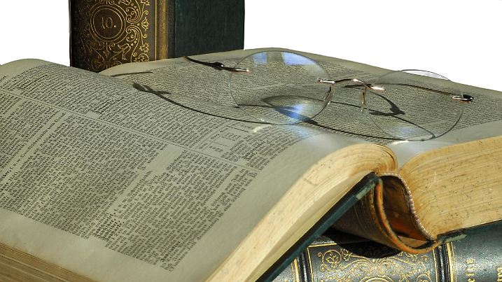 Lesebrille auf einem geöffneten Band einer alten Ausgabe von Meyers Lexikon | Verwendung weltweit, Keine Weitergabe an Wiederverkäufer.