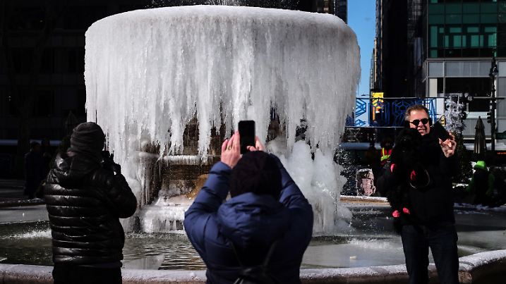 (190131) -- NEW YORK, Jan. 31, 2019 () -- People take pictures in front of a frozen fountain in Bryant Park in New York, the United States, Jan. 31, 2019. The freezing weather caused by the polar vortex in the midwest United States has expanded to New York since Wednesday with snowfalls and strong wind gusts, sending temperatures to the single digits Fahrenheit, or below -12 degrees Celsius. (/Li Muzi) |