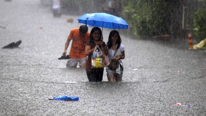 epa02260262 Fillipinos wade through a flooded street in San Juan suburb, east of Manila, Philippines on 25 July 2010. Heavy downpour pounded Metro Manila as the Inter-tropical Convergence Zone continued to hover across the country, the Philippine Atmospheric, Geophysical and Astronomical Services Administration (PAGASA) weather burea said.  The weather bureau added that 45.15mm of rains per hour as heavy rainfall; Typhoon Ketsana (Ondoy) last 2009  rate 56.33mm/hr.  EPA/DENNIS M. SABANGAN |