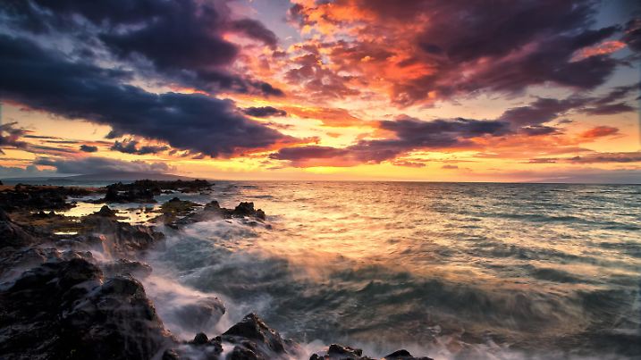 Dramatic Colourful Sky At Sunset Over The Pacific Ocean And The Rugged Coastline Of A Hawaiian Island; Hawaii, United States Of America | Verwendung weltweit, Keine Weitergabe an Wiederverkäufer.