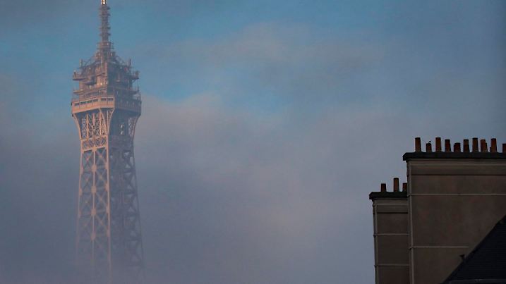 ARCHIV - 27.11.2015, Frankreich, Paris: Die Spitze vom Eiffelturm ragt aus tiefhängenden Wolken. (zu 130 Jahre Eiffelturm) Foto: Ian Langsdon/EPA/dpa +++ dpa-Bildfunk +++