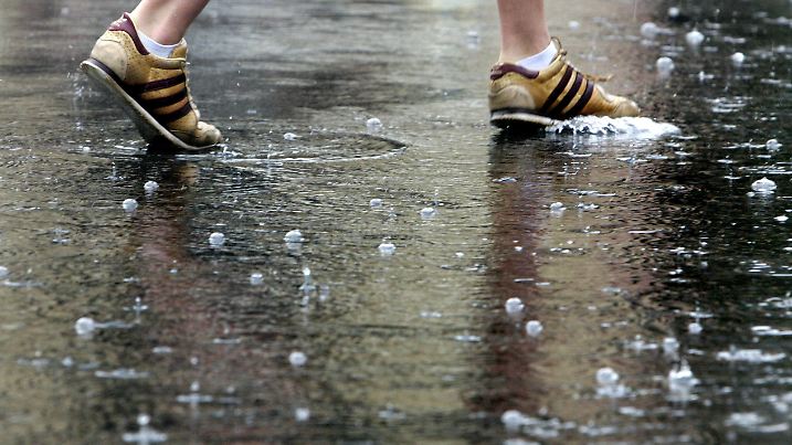 Eine Fußgängerin überquert am Donnerstag (21.06.2007) eine Straße in der Innenstadt von Frankfurt, die nach Gewittern und Dauerregen unter Wasser steht. Heftige Regenfälle sorgten in der Nacht und am Morgen in Hessen für zahlreiche Verkehrbehinderungen. Foto: Frank Rumpenhorst dpa/lhe +++(c) dpa - Report+++ | Verwendung weltweit
