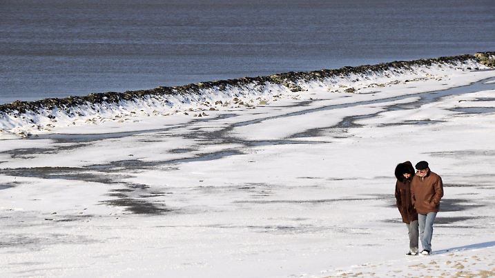Spaziergänger genießen bei Emden am Sonntag (01.02.2009) bei eiskaltem Ostwind die Mittagssonne am verschneiten Ufer der Emsmündung. Auch für die kommenden Tage sagen Meteorologen Temperaturen um den Gefrierpunkt voraus. Foto: Hans-Christian Wöste dpa/lni +++(c) dpa - Bildfunk+++