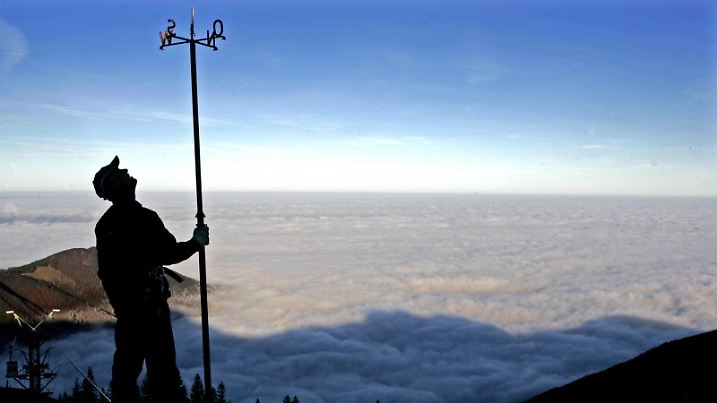 Ein Techniker der Kampenwandbahn kontrolliert am Freitag (25.11.2011) auf der Bergstation bei Aschau im Landkreis Rosenheim über dem morgendlichen Nebel im Tal einen Windmesser der Bahn. Die Bergbahnen nutzen das immer noch gute Wetter für Revisionen und Instandhaltungen. Foto: Diether Endlicher dpa/lby +++(c) dpa - Bildfunk+++