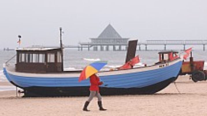 Ein Spaziergänger läuft am Dienstag (04.11.2008) bei nebligen Herbstwetter am Strand des Seebades Heringsdorf auf der Insel Usedom an einem Fischerboot vorbei. Hochnebel und teils Sprühregen sollen sich bis Wochenmitte fortsetzen. Foto:Stefan Sauer dpa/lmv +++(c) dpa - Bildfunk+++