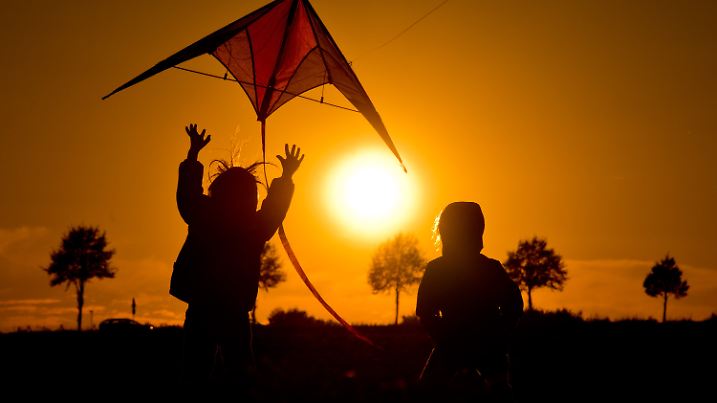 ARCHIV - Zwei Mädchen lassen am 30.09.2013 beim Sonnenuntergang auf einem Feld bei Hannover (Niedersachsen) einen Drachen steigen. Foto: Julian Stratenschulte/dpa (zu dpa "Der Herbst kommt: die schönen und die tristen Seiten" vom 31.08.2015) +++(c) dpa - Bildfunk+++