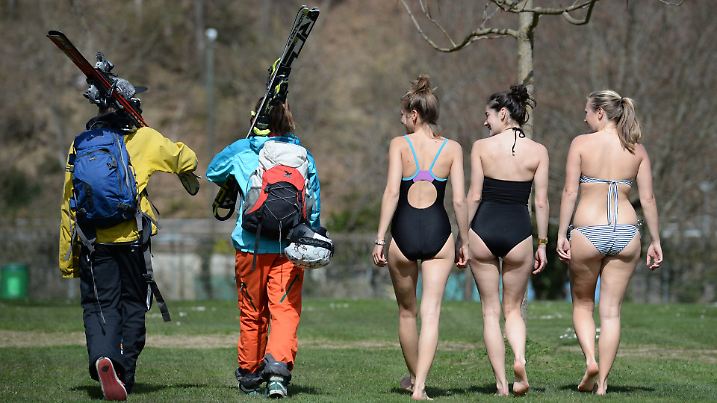 ARCHIV - Ein Paar in Skibekleidung sucht am 10.04.2015 im Strandbad in Freiburg (Baden-Württemberg) ein freien Platz für das Sonnenbad. Neben ihnen laufen drei Besucherinnen des Strandbades in Schwimmbekleidung. Die beiden Skifahrer kamen direkt vom Feldberg ins Schwimmbad. Foto: Patrick Seeger/dpa +++(c) dpa - Bildfunk+++