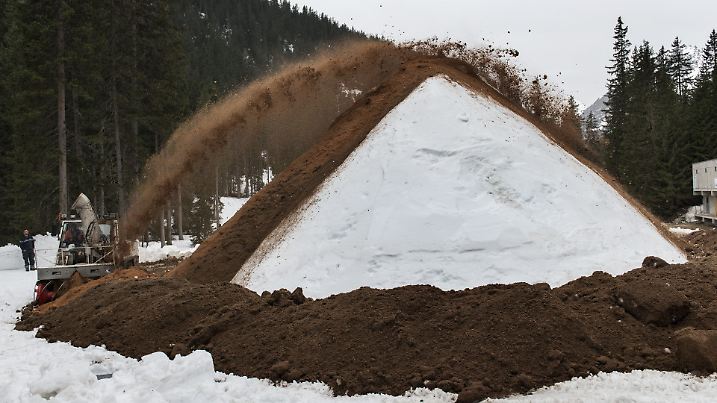 Mit einer Schleuder wird ein Haufen Schnee mit Saegemehl bedeckt, aufgenommen am 3. April 2014 in Davos. Beim Snowfarming wird Kunstschnee angehaeuft und anschliessend mit feuchtem Saegemehl bedeckt. Beim Trocknen dehnt sich die Saegemehlschicht aus und isoliert den Schnee. Der Schnee wird so uebersommert und in der darauffolgenden Saison fuer die Langlaufloipe gebraucht.