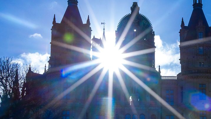 23.02.2024, Mecklenburg-Vorpommern, Schwerin: Die Sonne scheint hinter den Türmen des Schweriner Schlosses. Nach den stürmischen Nachtstunden zeigt sich das Wetter in Norddeutschland sonnig und mit Temperaturen bis zu zehn Grad. Foto: Jens Büttner/dpa +++ dpa-Bildfunk +++