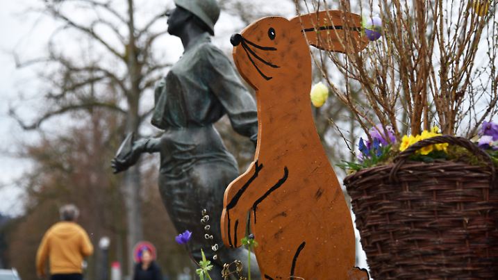 Ein Holz-Osterhase sitzt am 24.03.2016 in Bad Wildungen (Hessen) neben der Kurschattenfigur. Foto: Uwe Zucchi/dpa +++(c) dpa - Bildfunk+++