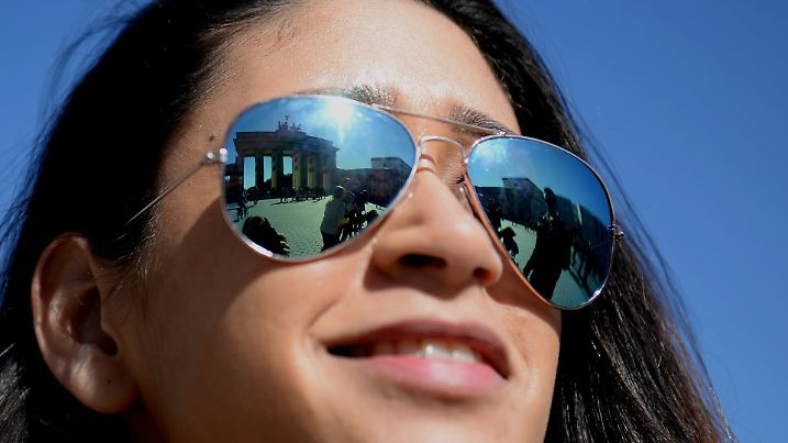 In der Sonnenbrille von Iris aus Holland spiegelt sich am 01.04.2016 in Berlin das Brandenburger Tor. Foto: Susann Prautsch/dpa +++(c) dpa - Bildfunk+++