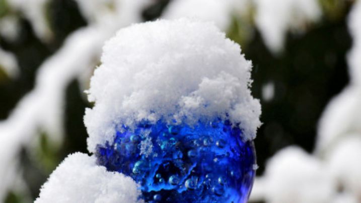 Schnee liegt am 14.10.2015 in einem Vorgarten bei Warstein (Nordrhein-Westfalen) auf einer blauen Glaskugel. In der Nacht zum Mittwoch fielen bis in tiefere Lagen die ersten Schneeflocken. Foto: Jörg Taron/dpa +++(c) dpa - Bildfunk+++