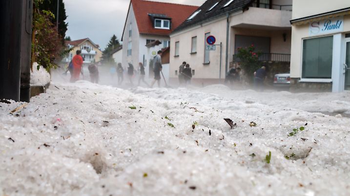 dpatopbilder Bürger reinigen am 27.05.2016 im Stadtteil Kloppenheim von Wiesbaden (Hessen) eine Straße, nachdem ein schweres Unwetter mit Hagel durchgezogen war. Foto: Dennis Altenhofen/Wiesbaden 112/dpa (zu dpa «Viele Keller nach Unwetter vollgelaufen» vom 27.05.2016) +++(c) dpa - Bildfunk+++