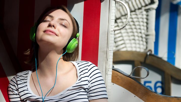 ILLUSTRATION - Eine junge Frau sitzt am 21.05.2014 im Bürgerpark Pankow in Berlin in einem Strandkorb und hört Musik. Foto: Franziska Koark