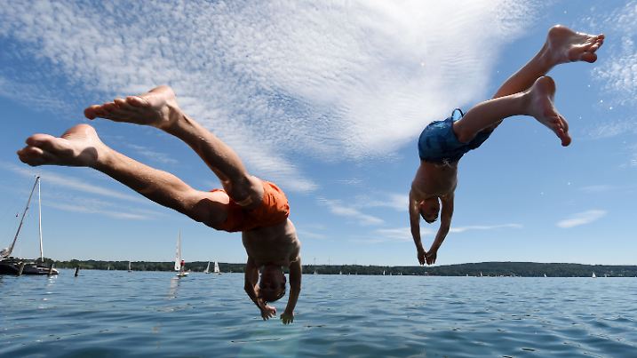 Zwei junge Männer springen am 10.07.2016 in Starnberg (Bayern) am Starnberger See ins Wasser. Foto: Tobias Hase/dpa +++(c) dpa - Bildfunk+++
