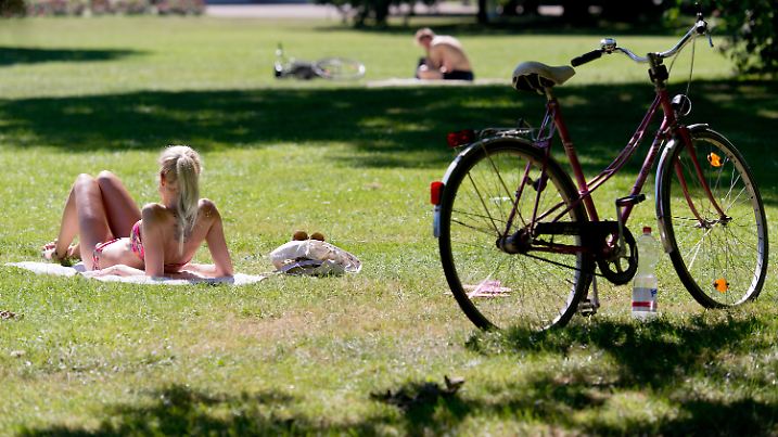 Eine junge Frau liegt am 24.08.2016 in Hannover (Niedersachsen) neben ihrem Fahrrad in der Sonne. Foto: Sebastian Gollnow/dpa +++(c) dpa - Bildfunk+++