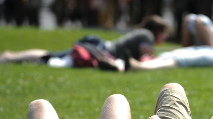 Das sonnige Wetter genießen unter anderem drei junge Männer, die am Dienstag (30.06.2009) im Lustgarten in Berlin auf dem Rasen liegen. Am kommenden Mittwoch soll sich laut Meteorologen erneut zeitweise die Sonne durchsetzen.  Foto: Rainer Jensen dpa/lbn +++(c) dpa - Bildfunk+++