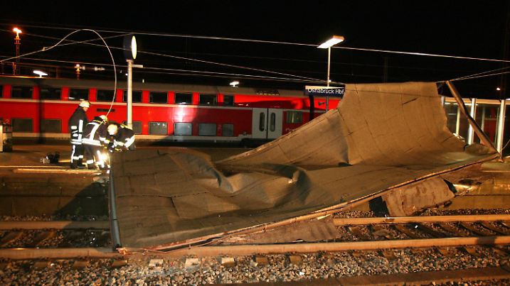 Feuerwehrleute bergen am Donnerstag (18.01.2007) auf Gleis 2 des Hauptbahnhofes in Osnabrück den Teil eines Daches vom Stellwerk, das erst auf die Oberleitung und dann auf das Gleis gefallen war. Die Deutsche Bahn stellt wegen des Orkans "Kyrill" bundesweit den gesamten Zugverkehr ein. Alle Züge würden in die Bahnhöfe gefahren, sagte ein Sprecher der dpa. Wie viele Reisende davon betroffen sind, ist noch unklar. Foto: Friso Gentsch dpa/lni +++(c) dpa - Bildfunk+++
