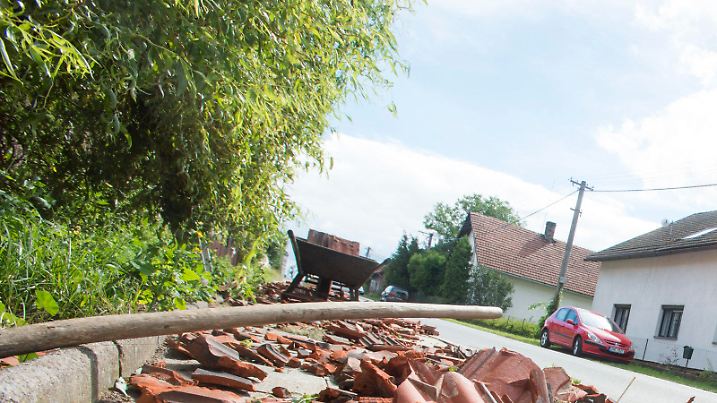 Eine Frau fegt am 12.08.2017 in Bohuslavice (Tschechien) herabgefallene Ziegeln zusammen. Heftige Stürme haben in Polen und Tschechien große Schäden angerichtet. Im Osten Tschechiens wurden nach Angaben der Nachrichtenagentur CTK seit Freitagabend mindestens 80 Häuser beschädigt, viele Dächer wurden zur Gänze angerissen. (zu dpa «Vier Tote in Polen und schwere Unwetterschäden in Tschechien» vom 12.08.2017) Foto: Vostárek Josef/CTK/dpa +++(c) dpa - Bildfunk+++