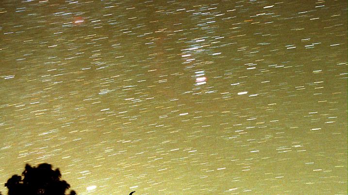 Der Sternschnuppenstrom der Leoniden am 19.11.1999 an einem wolkenlosen Himmel in der Nähe von Valencia. Bei der Silhouette des Stiers handelt sich um eine Reklametafel. Ursache für den Leonidenstrom ist der Komet "Tempel-Tuttle", der in 33 Jahren einmal die Sonne umrundet. Wenn er auf seiner elliptischen Bahn der Sonne besonders nahe komme, werden Staubteilchen aus dem Kometen hinausgeschleudert, die dann meist leicht versetzt hinter ihm her ziehen. Jedes Jahr kommt die Erde bei ihrem Umlauf um die Sonne in die Bahnnähe des Kometen. Dann treten die millimeter- bis zentimetergroßen Partikel  in die Erdatmosphäre ein und verglühen als Sternschnuppe. In den meisten Teilen Deutschlands verdeckten leider dichte Wolken die Sicht.ACHTUNG: Die sichtbaren Streifen zeigen in der Regel Lichtspuren von Sternen,  Satelliten, der ISS oder Luftmolekülen. Meteoriten  (Sternschnuppen) sind aufgrund der kurzen Zeit des Einschlages und der relativ geringen Lichtintensität meist nicht fotografierbar.