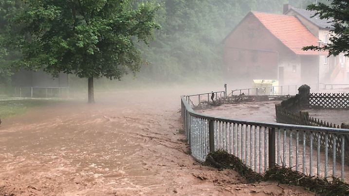 ARCHIV - 27.05.2018, Hessen, Hetzerode: Nach Starkregen und Hagelschlag ist ein Bach über die Ufer getreten. Feuerwehren und Rettungskräfte sind in der Region im Einsatz und pumpen überflutete Keller leer und räumen Schlammlawinen. Foto: Bernd März/dpa-Zentralbild/dpa +++ dpa-Bildfunk +++