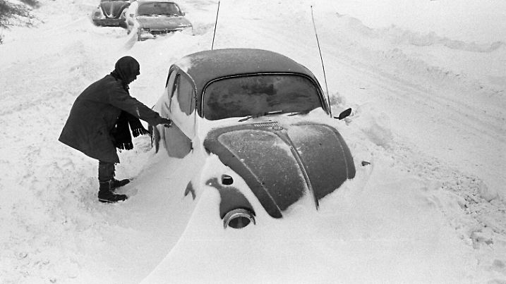 ARCHIV - 31.12.1978, Schleswig-Holstein, Cuxhaven: Ein Autofahrer steht neben seinem am Straßenrand im Schnee stecken gebliebenen VW-Käfer, aufgenommen bei Cuxhaven am 31.12.1978. Der Temperatursturz vom 29. Dezember 1978 führte in Norddeutschland, dem Norden der DDR, Dänemark und Südschweden zu einem Schneechaos. (Zu dpa "Schneekatastrophe vor 40 Jahren" vom 27.12.2018) Foto: Werner Schilling/dpa +++ dpa-Bildfunk +++